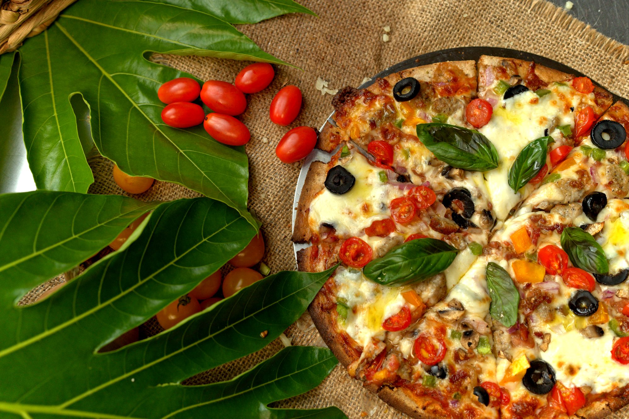 Pizza de pana con vegetales, albahaca y hojas de árbol de pana